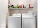 Bright laundry room with modern washer and dryer, and a shelf for storage at 20615 N 105Th Ave, Peoria, AZ 85382