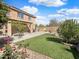 Spacious backyard featuring an expansive lawn, concrete patio, and manicured garden beds at 22359 W Desert Bloom St, Buckeye, AZ 85326