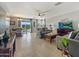 Spacious living room with tile floors, comfortable seating, ceiling fan and bright light at 22359 W Desert Bloom St, Buckeye, AZ 85326