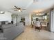 Open-concept living room flowing into the kitchen, featuring tile flooring and natural light at 22359 W Desert Bloom St, Buckeye, AZ 85326