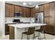 Kitchen showcasing a central island, stainless appliances, and wood cabinetry at 2477 W Market Pl # 18, Chandler, AZ 85248