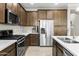 Kitchen with stainless steel appliances, wood cabinets, and stone countertops at 2477 W Market Pl # 18, Chandler, AZ 85248