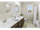 Bright bathroom with double sinks, a large mirror, and a shower-tub combination at 2477 W Market Pl # 18, Chandler, AZ 85248