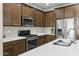 Kitchen with stainless steel appliances, light countertops, and wooden cabinetry at 2477 W Market Pl # 18, Chandler, AZ 85248