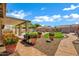 Charming backyard with green lawn, desert landscaping, and a covered patio at 2561 E Toledo Ct, Gilbert, AZ 85295