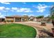Large backyard featuring a pool, patio, mature palm trees and landscaping at 2561 E Toledo Ct, Gilbert, AZ 85295