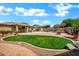 Spacious backyard featuring a grassy lawn, patio, pool, and desert landscaping at 2561 E Toledo Ct, Gilbert, AZ 85295