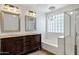 Luxurious bathroom with double sinks, ornate vanity, and a separate shower and tub at 2561 E Toledo Ct, Gilbert, AZ 85295