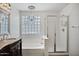 Elegant bathroom with separate shower and tub, glass block window, and ornate vanity at 2561 E Toledo Ct, Gilbert, AZ 85295
