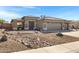 Single-story home featuring desert landscaping, a three-car garage and a covered entryway at 2561 E Toledo Ct, Gilbert, AZ 85295