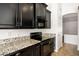 Close-up view of the kitchen featuring black cabinets, stainless steel appliances, and granite countertops at 2561 E Toledo Ct, Gilbert, AZ 85295