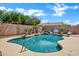 Refreshing backyard pool area with rock waterfall feature and lush greenery at 2561 E Toledo Ct, Gilbert, AZ 85295