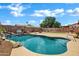 Sparkling pool with a rock waterfall feature and mature landscaping at 2561 E Toledo Ct, Gilbert, AZ 85295