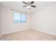 A carpeted room features a ceiling fan and a window that provides natural light at 25916 N 161St Ave, Surprise, AZ 85387