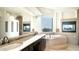 Luxurious bathroom with dual sinks, soaking tub, tiled walls, and fireplace at 3168 S Yaqui Ln, Gold Canyon, AZ 85118