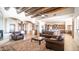 Spacious living room boasts wood beam ceilings, tile floors and comfortable leather seating at 3168 S Yaqui Ln, Gold Canyon, AZ 85118