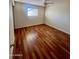 This empty bedroom features glossy hardwood floors, a ceiling fan, and natural light at 3415 W Orchid Ln, Phoenix, AZ 85051