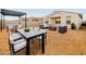 This backyard features an outdoor dining set, a fire pit, and an outdoor couch at 36986 W Prado St, Maricopa, AZ 85138