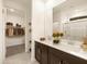 Bathroom featuring a dual sink vanity with sleek fixtures, quartz countertops, and a walk-in closet at 36986 W Prado St, Maricopa, AZ 85138