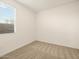 Clean bedroom with neutral carpet, a window with blinds, and ample natural light at 36986 W Prado St, Maricopa, AZ 85138