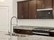 Modern kitchen featuring stainless steel appliances, granite countertops, and dark wood cabinetry at 36986 W Prado St, Maricopa, AZ 85138
