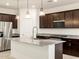 Modern kitchen featuring dark wood cabinets, granite countertops, and stainless steel appliances at 36986 W Prado St, Maricopa, AZ 85138