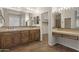 Bright bathroom featuring dual sinks, wood cabinets, and a large mirror with ample lighting at 4116 E Sierra Sunset Trl, Cave Creek, AZ 85331
