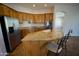 A well-appointed kitchen featuring an island with a sink, stainless steel refrigerator, and wooden cabinetry at 4116 E Sierra Sunset Trl, Cave Creek, AZ 85331