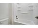 Clean white bathroom with a tub and shower, featuring built-in shelving at 4240 W Crossflower Ave, San Tan Valley, AZ 85144