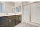Modern bathroom features a double vanity with a large mirror and a glass-enclosed shower with white tile surround at 4240 W Crossflower Ave, San Tan Valley, AZ 85144
