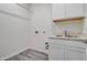 Laundry room with white cabinets, a sink and new vinyl flooring at 4240 W Crossflower Ave, San Tan Valley, AZ 85144