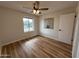 Cozy bedroom with wood floors, ceiling fan, and ample natural light from window at 4524 W Larkspur Dr, Glendale, AZ 85304