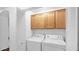 Laundry room with a white washer and dryer, complemented by wooden cabinets above at 4533 N 22Nd St # 228, Phoenix, AZ 85016