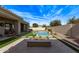 Beautiful backyard features a sparkling pool with grass and stone landscaping, plus a fire pit for outdoor entertaining at 4667 E Reins Rd, Gilbert, AZ 85297