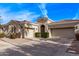 Expansive home exterior with multiple garage doors, arched entryway, and neat desert landscaping at 4667 E Reins Rd, Gilbert, AZ 85297