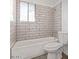 Bathroom featuring a white tiled shower-tub combo with a toilet at 4714 E Belleview St, Phoenix, AZ 85008