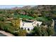Expansive estate with a pool, set against a backdrop of golf course and mountains, offering luxury and scenic views at 4900 E Desert Fairways Dr, Paradise Valley, AZ 85253
