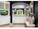 Elegant bathroom with a decorative mirror, white cabinetry, and a comfortable bench at 4900 E Desert Fairways Dr, Paradise Valley, AZ 85253