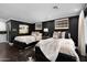 This bedroom has two beds, dark hardwood floors, and black walls at 4900 E Desert Fairways Dr, Paradise Valley, AZ 85253