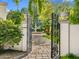 Ornate wrought iron gate opens to a lush garden with a charming water fountain, enhancing the property's curb appeal at 4900 E Desert Fairways Dr, Paradise Valley, AZ 85253