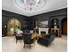 Sophisticated living room with high ceilings, a fireplace, dark walls, and stylish furniture, creating a cozy atmosphere at 4900 E Desert Fairways Dr, Paradise Valley, AZ 85253