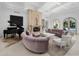 Bright and airy living room featuring a stone fireplace, grand piano, and elegant furnishings, perfect for relaxation at 4900 E Desert Fairways Dr, Paradise Valley, AZ 85253
