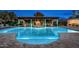 Luxury outdoor pool area featuring a covered patio with fireplace and elegant landscaping at 4900 E Desert Fairways Dr, Paradise Valley, AZ 85253