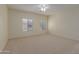 Sunny bedroom with neutral carpeting, ceiling fan, and bright natural light at 525 N Miller Rd # 220, Scottsdale, AZ 85257