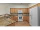 Functional kitchen featuring granite counters, oak cabinets, and white appliances at 525 N Miller Rd # 220, Scottsdale, AZ 85257