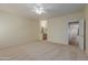 Large primary bedroom featuring neutral carpet, ceiling fan, and en-suite bathroom at 525 N Miller Rd # 220, Scottsdale, AZ 85257