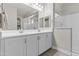 Bathroom with double vanity, white countertops and cabinets, and glass enclosed shower at 5825 N 107Th Ln, Phoenix, AZ 85037