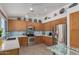 Modern kitchen with stainless steel appliances, blue tile backsplash, and light wood cabinetry at 6353 E Roland St, Mesa, AZ 85215