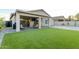 Green lawn, brick pavers and covered patio with hanging egg chairs at 6404 W Black Hill Rd, Phoenix, AZ 85083