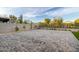 Expansive backyard with neutral color brick pavers and immature foliage at 6404 W Black Hill Rd, Phoenix, AZ 85083
